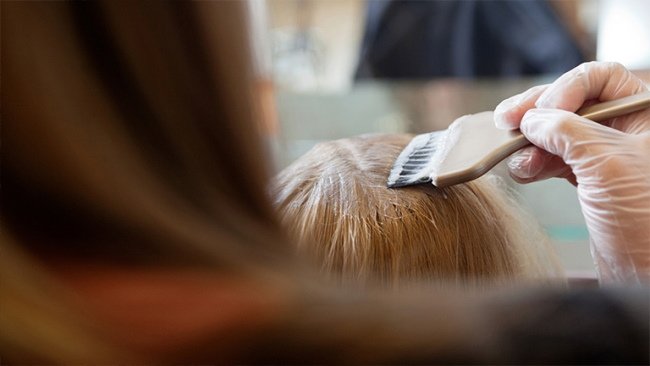 Девушке красят корни волос